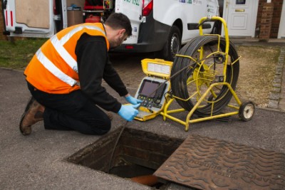 Envirodrain technician setting up a CCTV drain camera at a manhole